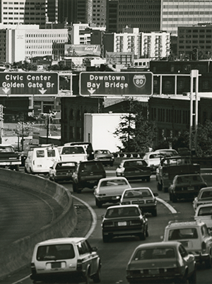 View of cars driving on Interstate 80 to the Bay Bridge. Traffic signs directing vehicles can be seen.