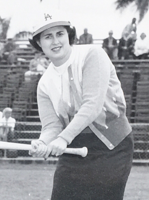 Portrait of a woman in a baseball cap, posing with a baseball bat